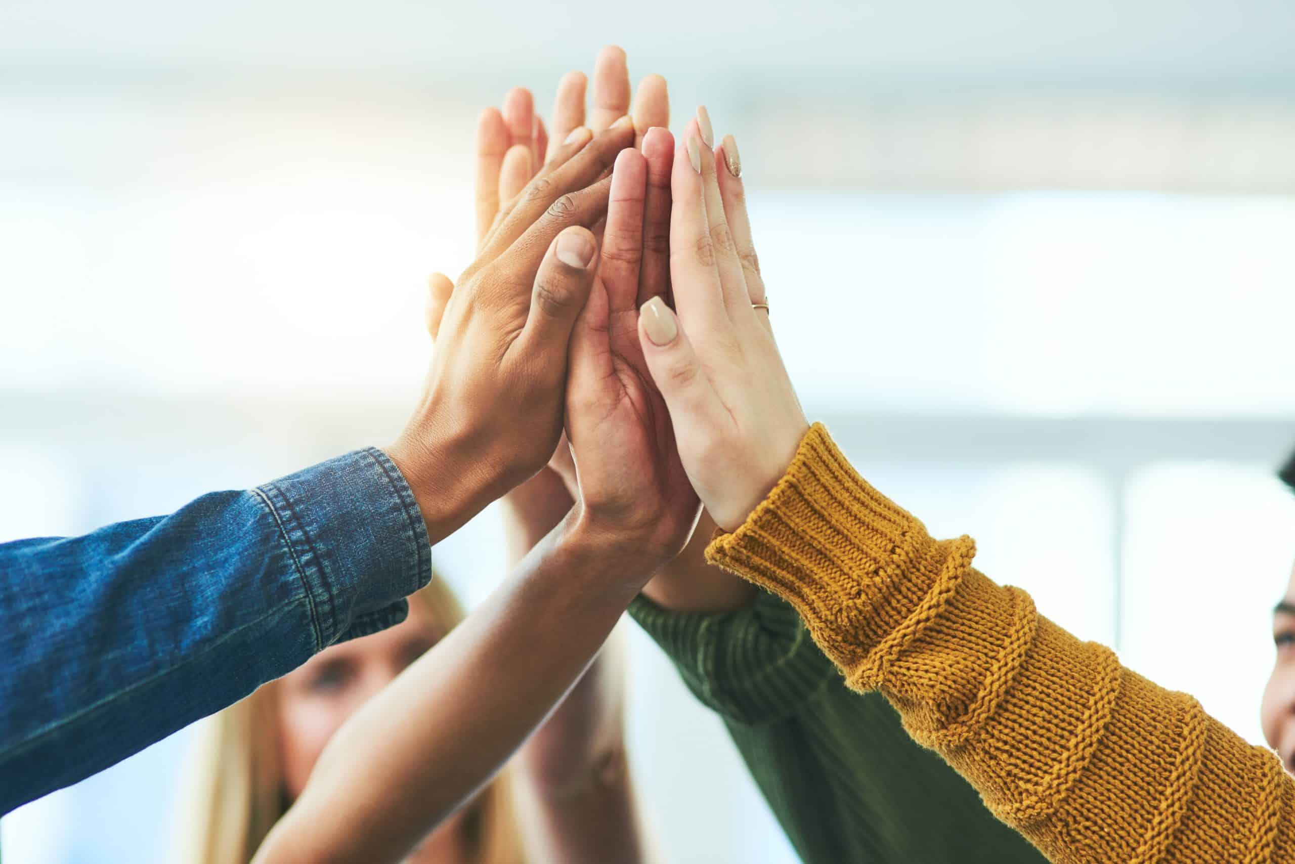 Closeup shot of a diverse group of people high fiving together