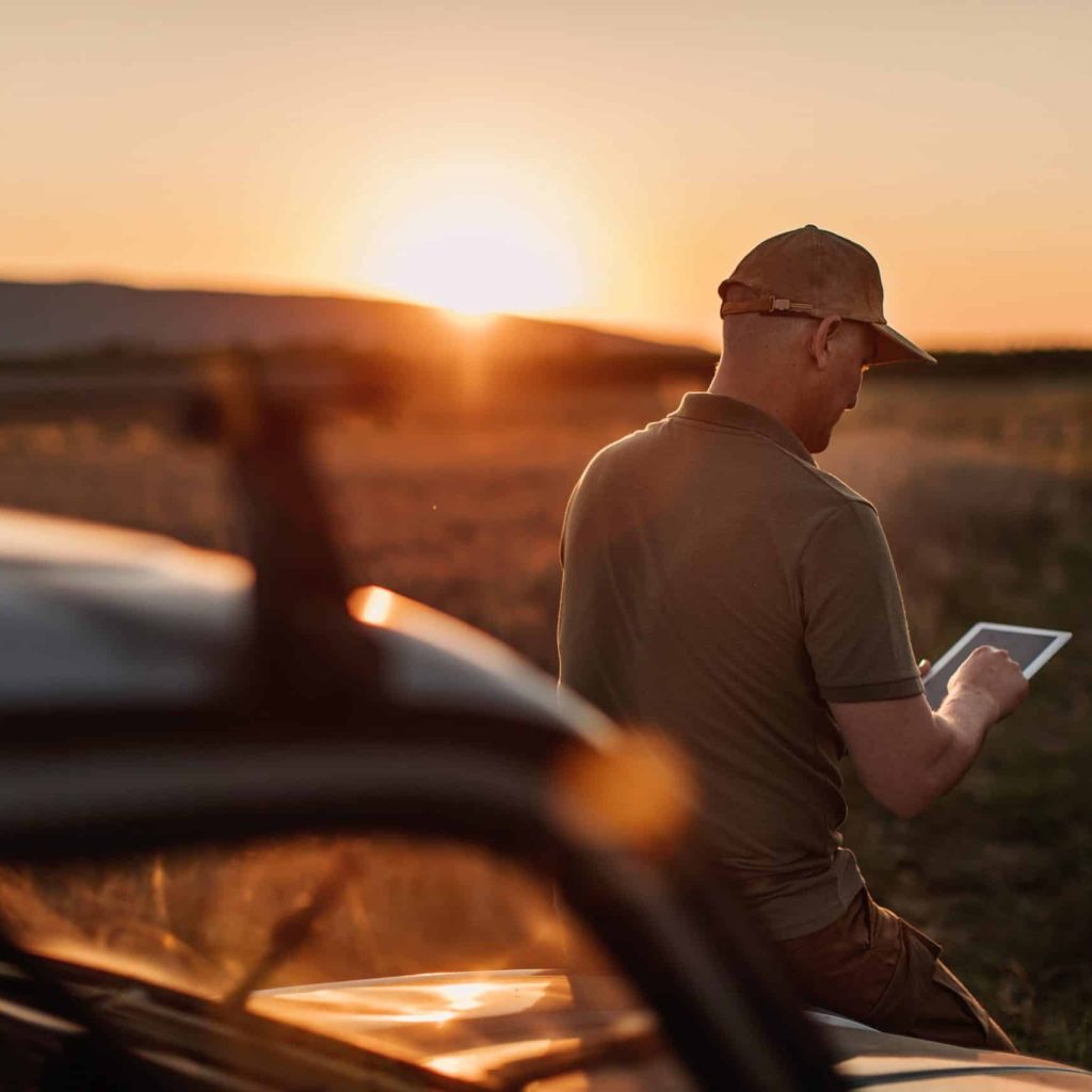 Mid adult farmer inspects his land