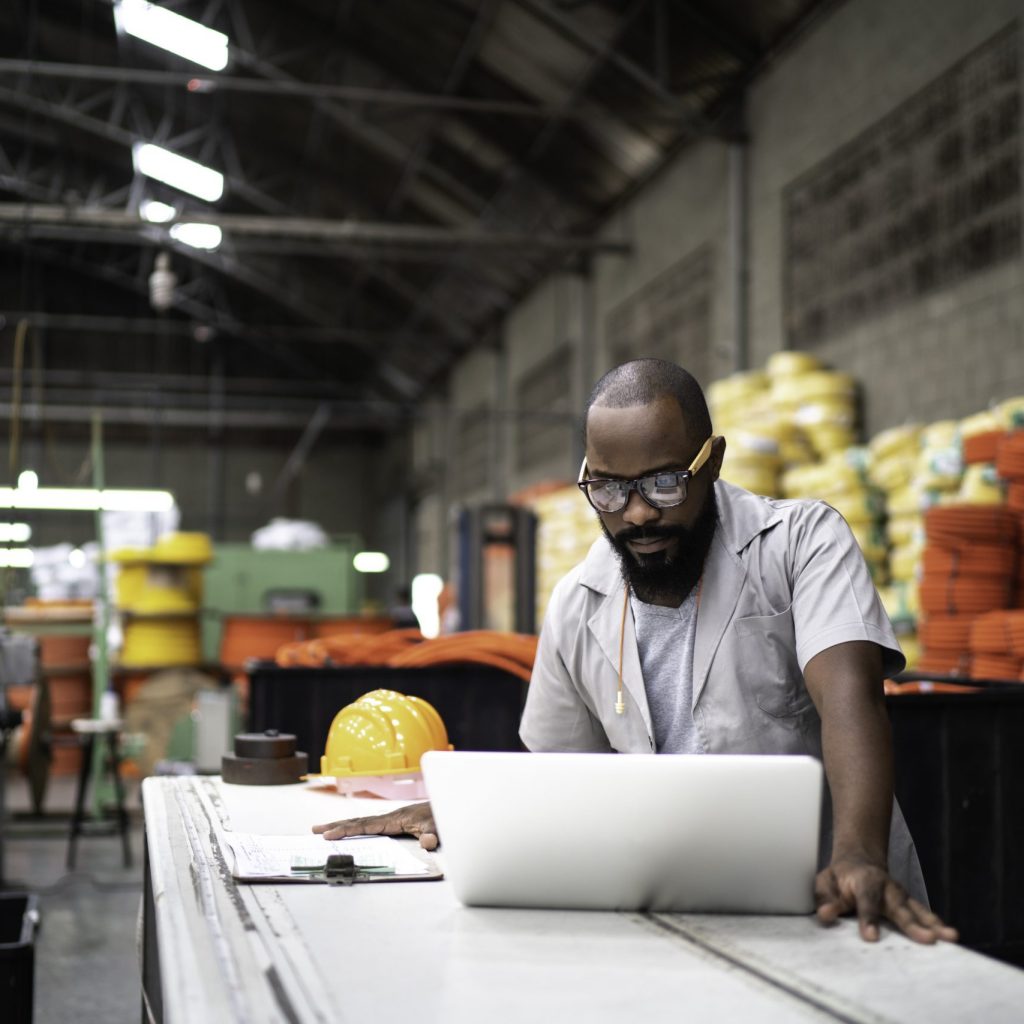 Engineer working at the factory using laptop