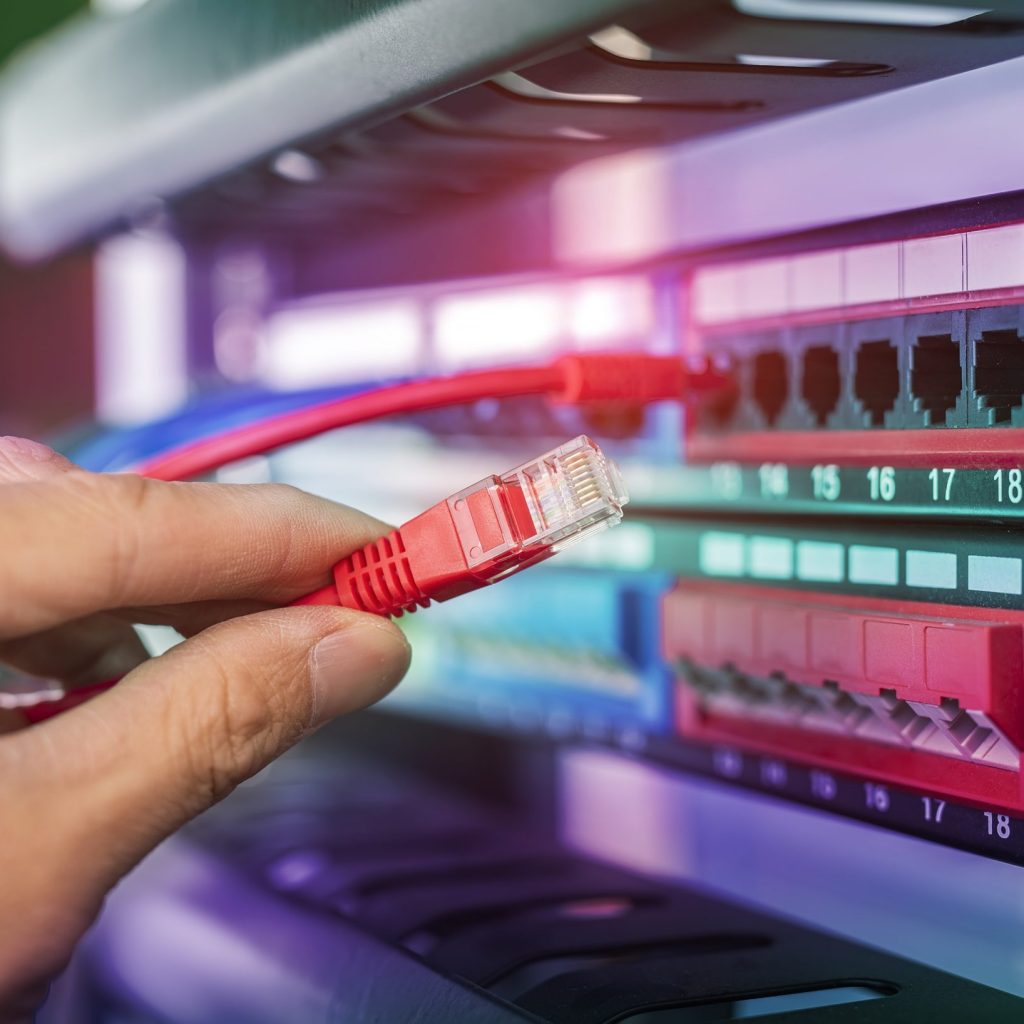 Man working in fiber optic network server room with network hub