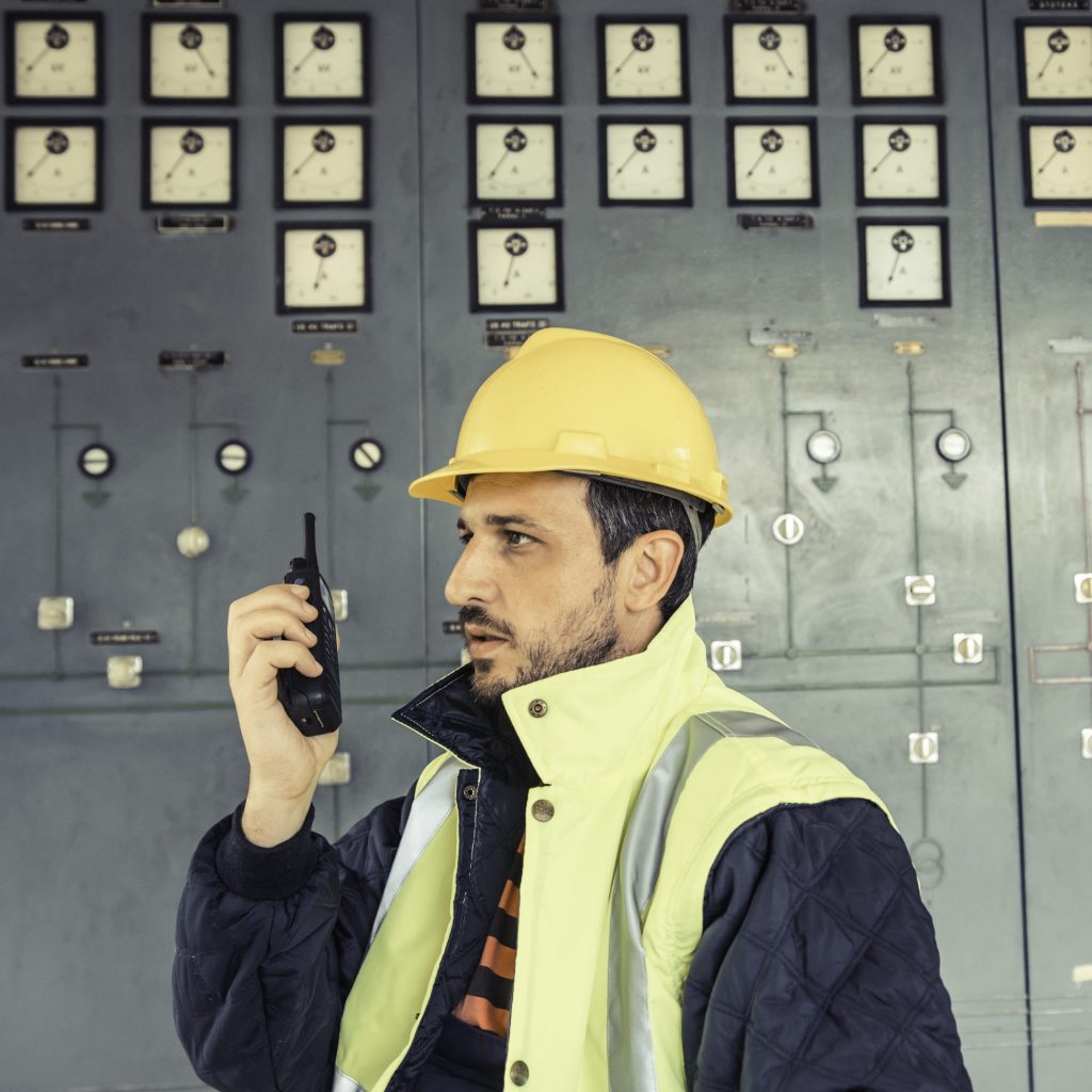 Mans hand holding cb radio. Industry background.