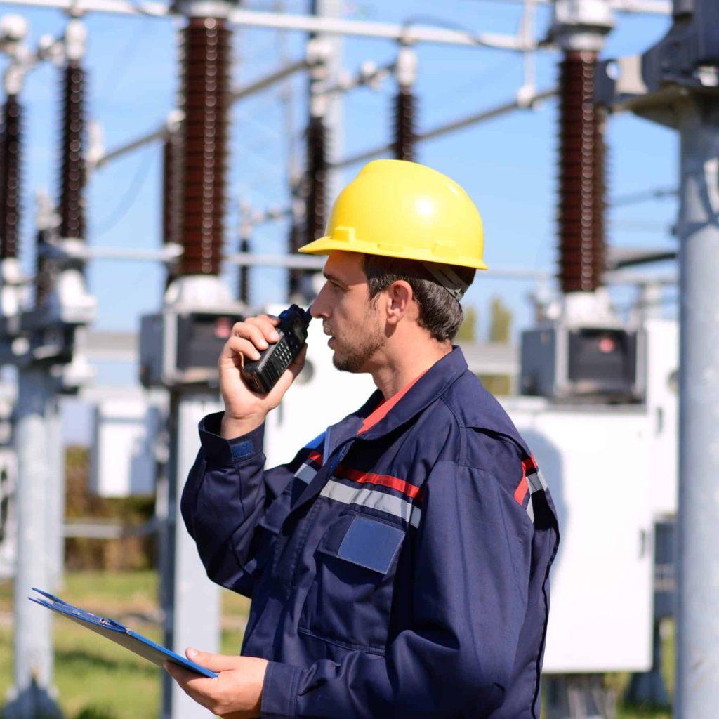 Electrician working in power plant. Man at work with Walkie Talkie and ring binder in his hand.