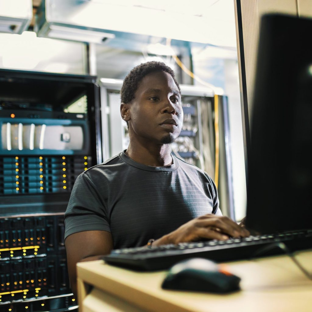 Network Monitoring in Alberta System administration, man is working in data center with laptop