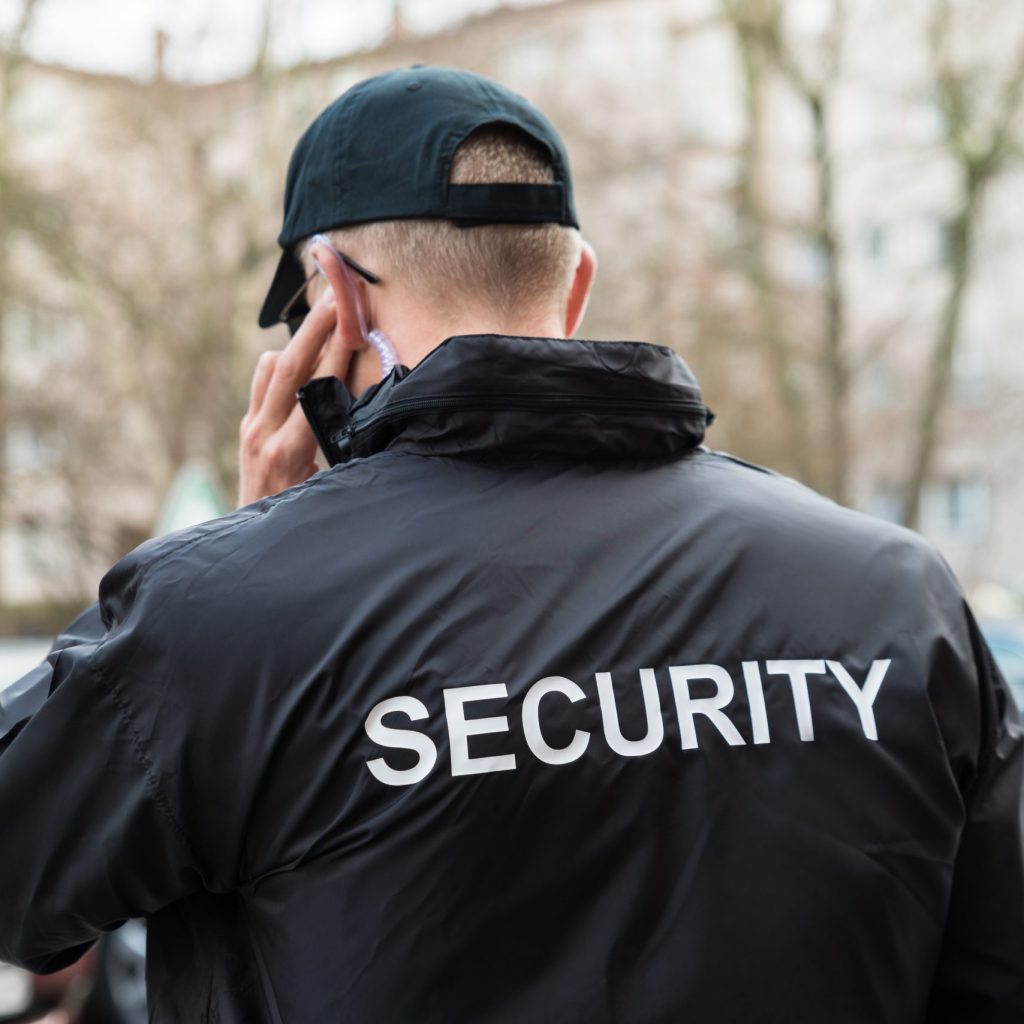 Security Two-Way Radio Earpiece In Alberta Security Guard In Black Uniform Listening With Earpiece