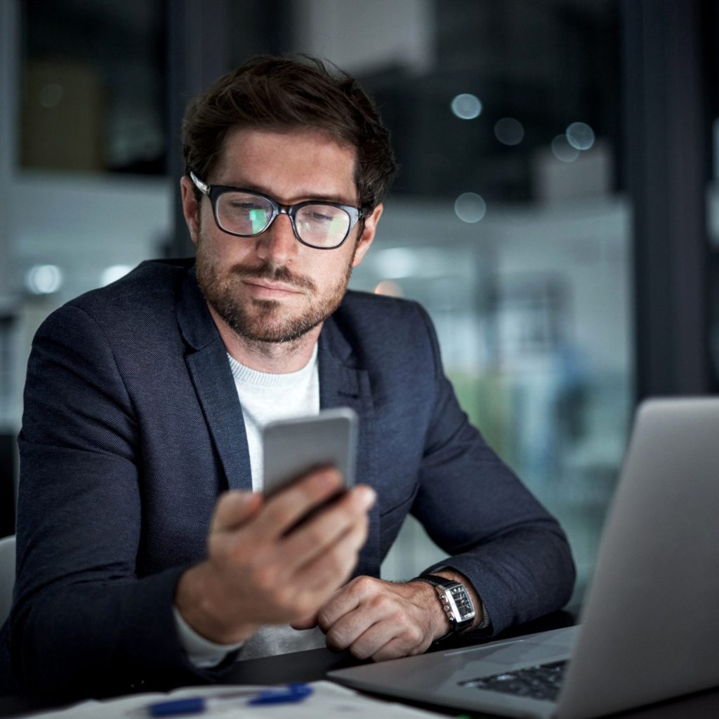 Telus Coverage Enhancement in Alberta Shot of a young businessman using his laptop and phone at work