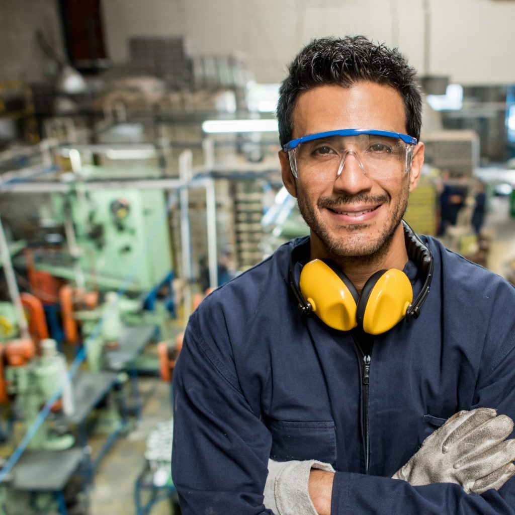 Latin American man working at a metal factory and wearing protective wear
