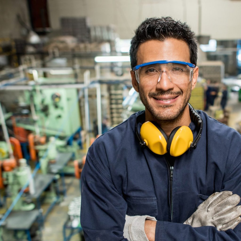 Tridon Manufacturing Communication Solutions Latin American man working at a metal factory and wearing protective wear
