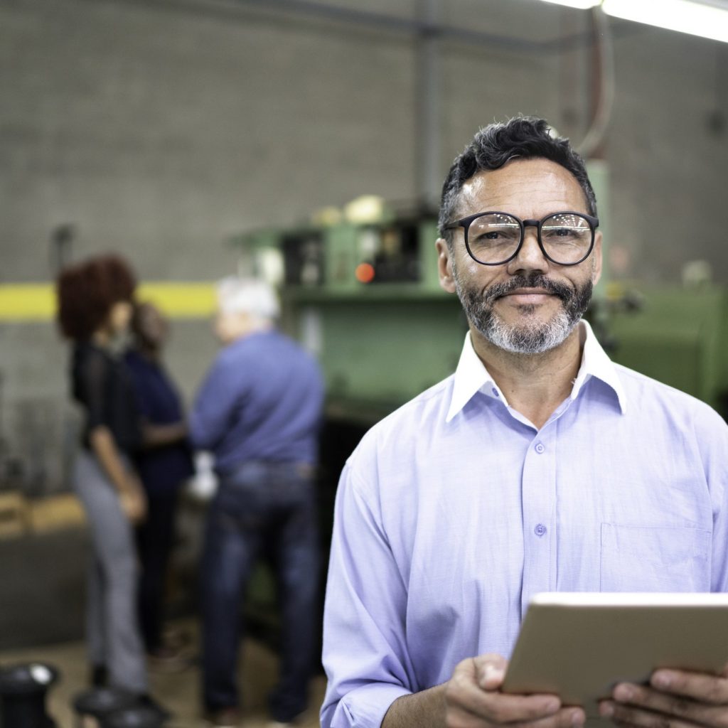 tridon communications in Alberta Portrait of a businessman using a digital tablet in the production line of a factory